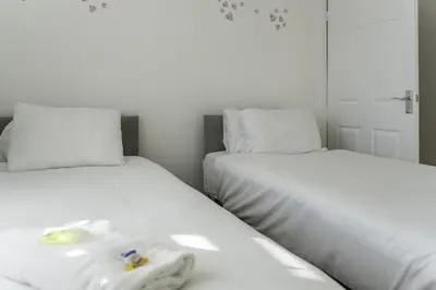 two beds sitting next to each other in a bedroom at 3 BDR House By Caledonia Luxe Stays Short Lets & Serviced Accommodation Airdrie in Airdrie