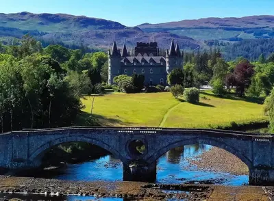 a bridge over a river with a castle in the background at Beolary in Oban