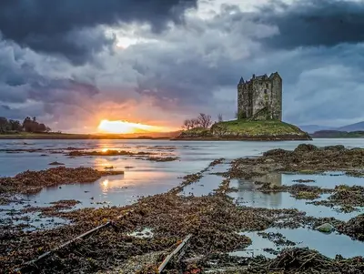an old castle on an island in the water at sunset at Beolary in Oban