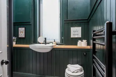 a green bathroom with a sink and a toilet at The Fairlie Suite No2 in Prestwick