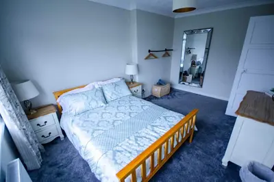 a bedroom with a bed and a large mirror at Spacious 4-Bedroom House in Glenboig in Glenboig