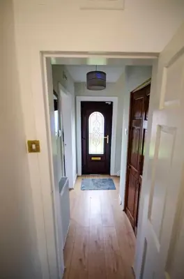 an empty hallway with a door and a window at Spacious 4-Bedroom House in Glenboig in Glenboig