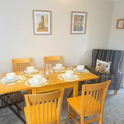 a dining room with a table with chairs and a table and chairsuggest at Spacious 4-Bedroom House in Glenboig in Glenboig