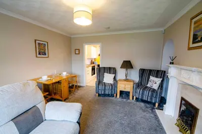 a living room with a couch and a fireplace at Spacious 4-Bedroom House in Glenboig in Glenboig