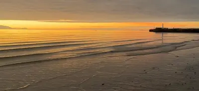 a beach with a pier and the ocean at sunset at No 10, Ayr, 130m2, New Decor December 2024, All new entire 3 bedroom garden house in Ayr