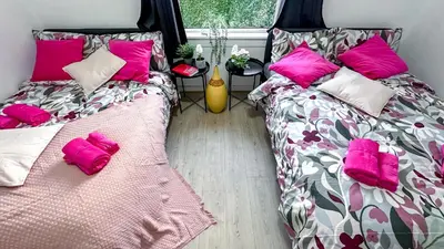 two beds in a room with pink pillows at Holly street house with Separate Entrance,Glasgow edge in Clydebank