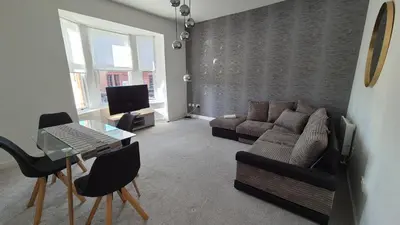 a living room with a couch and a table at Bellshill Central Apartment in Bellshill