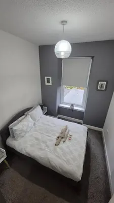 a bedroom with a bed with two towels on it at Bellshill Central Apartment in Bellshill