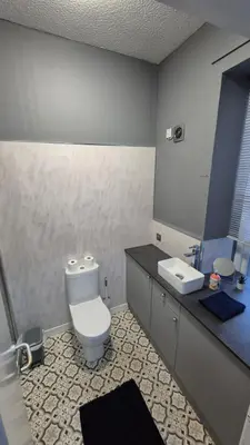 a bathroom with a toilet and a sink at Bellshill Central Apartment in Bellshill