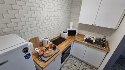 a small kitchen with a counter and a sink at Bellshill Central Apartment in Bellshill