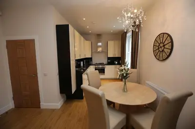 a kitchen and dining room with a table and chairs at Edinburgh Pearl Apartments - Dalry House Residence in Edinburgh