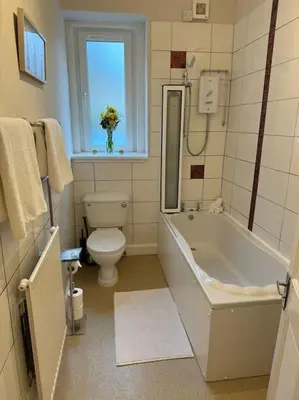 a bathroom with a tub and a toilet and a sink at Peaceful Place in Falkirk