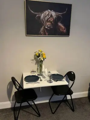 a table with two chairs and a picture of a bull at Peaceful Place in Falkirk