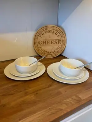 two white bowls and plates on a counter with a sign at Modern apartment in Stenhousemuir in Stenhousemuir