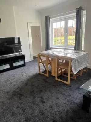a living room with a table and a window at Gogarstone Cottage in EDI