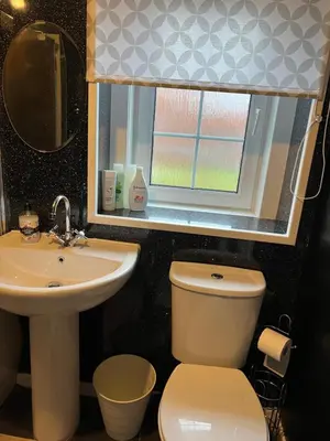a bathroom with a toilet and a sink and a window at Gogarstone Cottage in EDI