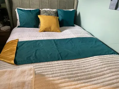 a bed with blue and yellow pillows on it at Harbury Lodge in Scotstoun West Station