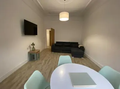 a living room with a table and chairs and a couch at 1 Smithhills Sleeps 5 Central and Spacious in Paisley