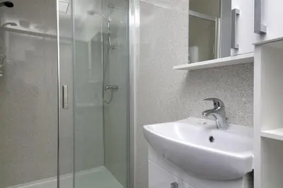 a bathroom with a sink and a glass shower at Modern City Centre Apartment in Central Hub in Edinburgh