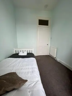 a bedroom with a white bed and a white door at Modern City Centre Apartment in Central Hub in Edinburgh