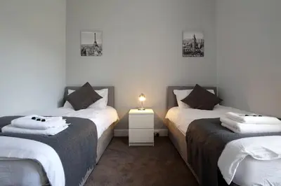 a bedroom with two twin beds and a night stand at Modern City Centre Apartment in Central Hub in Edinburgh