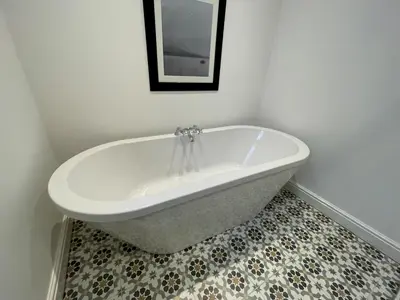 a white bath tub in a bathroom with a tile floor at Stunning Cosy Cottage in Historic Moffat - Pass the Keys in Moffat