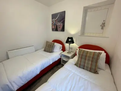 a bedroom with two beds and a mirror at Stunning Cosy Cottage in Historic Moffat - Pass the Keys in Moffat