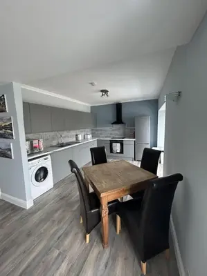 a kitchen with a wooden table and black chairs at Bielding View Tarbert Loch Fyne Argyll in Tarbert