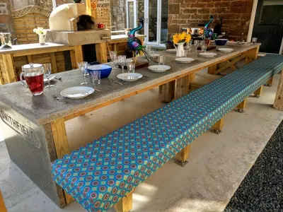 a long wooden table with a bench with plates on it at Family and dog friendly stunning barn conversion in Tarbolton