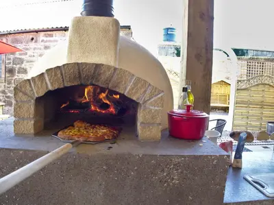 a pizza is being cooked in an outdoor oven at Family and dog friendly stunning barn conversion in Tarbolton