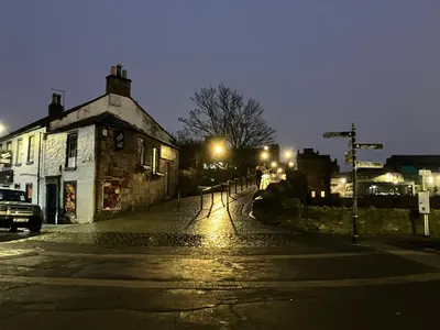 an empty street at night with a building and street lights at Apartment 28 in Ayr