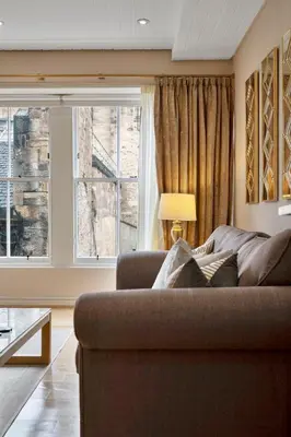 a living room with a couch and two windows at Rose Street flat in Edinburgh