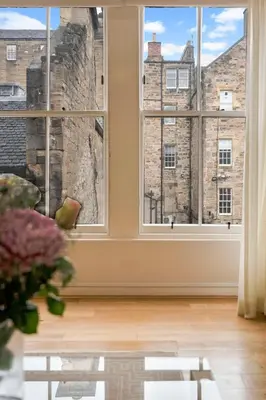 an empty room with windows and a table at Rose Street flat in Edinburgh