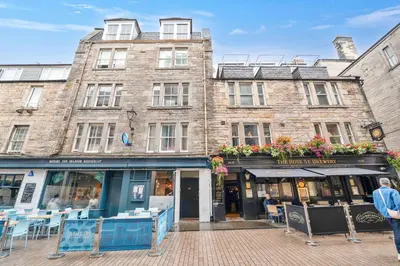 a building with tables and chairs in front of it at Rose Street flat in Edinburgh