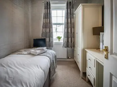 a small bedroom with a bed and a window at The Loans Inn Cottage in Loans