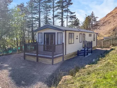 a small white tiny house on a hill at Katie's Cosy Caravan - Uk48380 in Ardgour