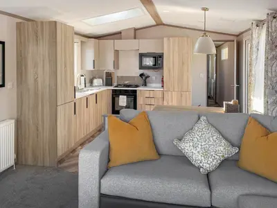 a living room with a couch and a kitchen at Katie's Cosy Caravan - Uk48380 in Ardgour