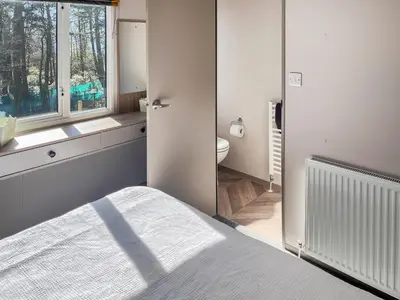 a bedroom with a bed and a bathroom with a window at Katie's Cosy Caravan - Uk48380 in Ardgour