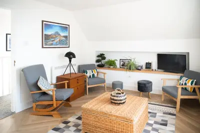 a living room with chairs and a tv at Modern apartment with stunning sea views near Oban in Connel