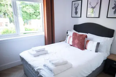 a bedroom with a white bed with towels on it at Modern apartment with stunning sea views near Oban in Connel