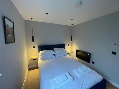 a bedroom with a large white bed with two pillows at River Logie Lodges in Westfield