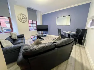 a living room with a couch and a table with chairs at 2 Bed apartment in city centre! in Glasgow
