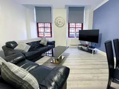 a living room with a couch and a flat screen tv at 2 Bed apartment in city centre! in Glasgow