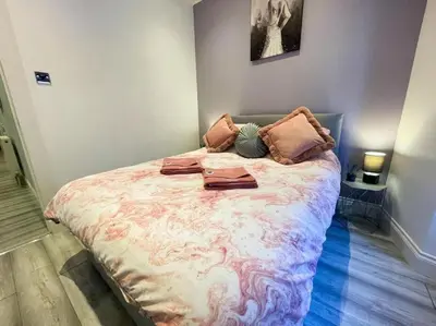 a bedroom with a large bed with pillows on it at 2 Bed apartment in city centre! in Glasgow