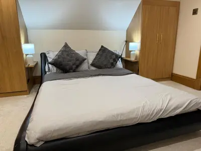 a large bed in a bedroom with two lamps at 2-Bed Cottage Sleeps 4 10 mins to Glasgow Centre in Glasgow
