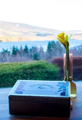 a vase with a flower in a bottle on a table at The Corries B&B in Luss