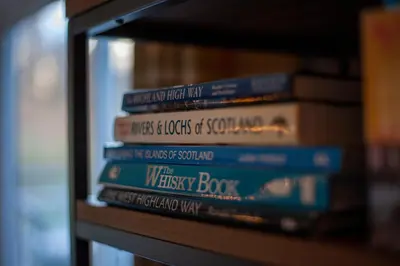 a stack of books sitting on a shelf at The Corries B&B in Luss