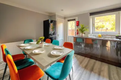 a kitchen and dining room with a table and chairs at Cosy 4 Bedroom Home In Glasgow City - Free Parking in Glasgow