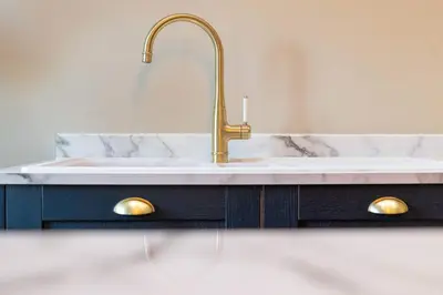 a bathroom sink with a gold faucet at The Oliver in Ayr