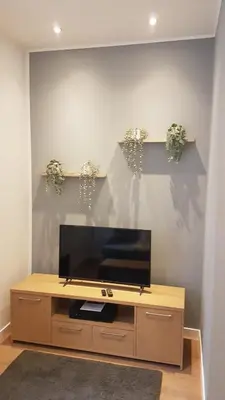 a flat screen tv sitting on top of a wooden entertainment center at CS Exclusive Apartments of Princess Street West End in Edinburgh